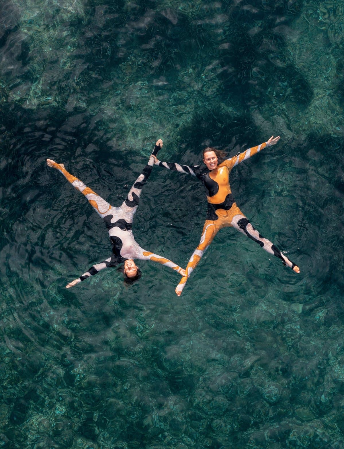 Beatriz Ryder Da Costa's winning aquatic photography showing synchronized divers emerging from mercury-like water