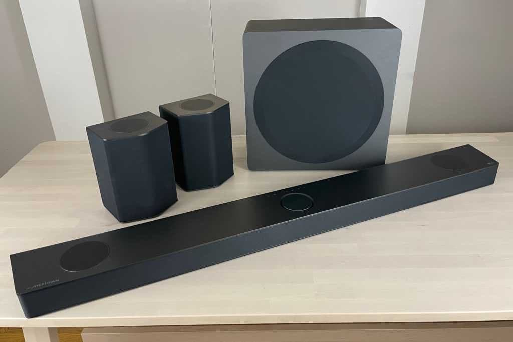 LG S95QR soundbar system with wireless subwoofer and rear speakers in living room setting