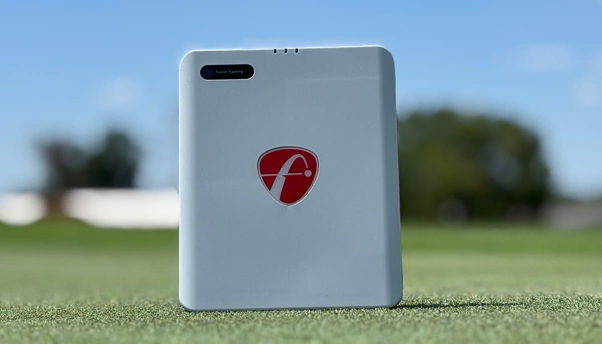 FlightScope Mevo Gen2 launch monitor on driving range with smartphone app displaying swing data