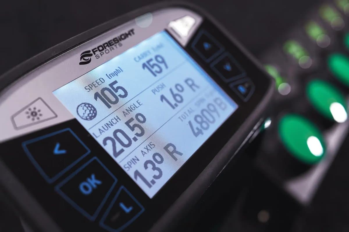 ProSendr launch monitor device displaying ball speed, launch angle, and distance metrics on smartphone app