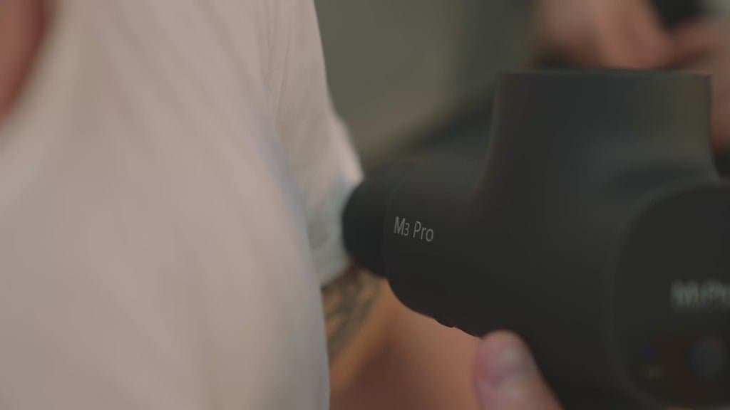 Professional-grade massage gun with heated therapy and wireless compression